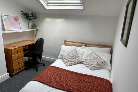 Cozy and well-lit bedroom featuring a comfortab...