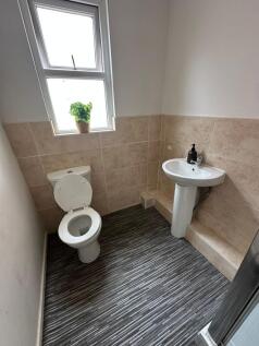 A clean and simple bathroom featuring a toilet,...