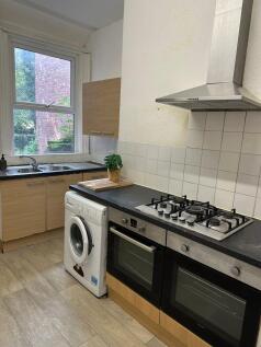 A well-lit kitchen featuring a large window ove...