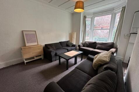 A spacious, well-lit living room featuring a la...