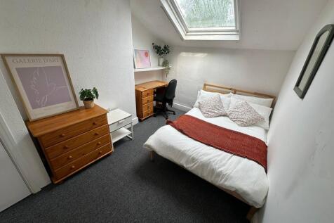 A bright and cozy bedroom featuring a double be...