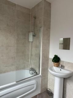 A clean and modern bathroom featuring a bathtub...