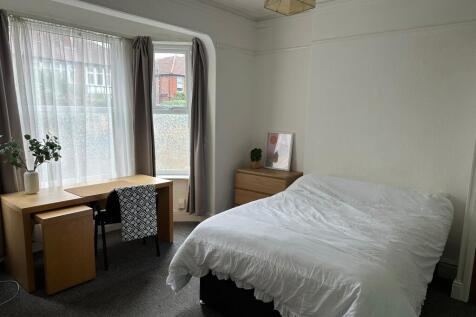 A bright and clean bedroom featuring a large wi...