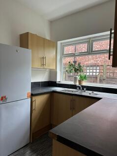 A bright and functional kitchen with wooden cab...