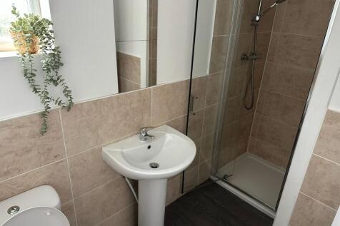 A modern, clean bathroom featuring a small sink...