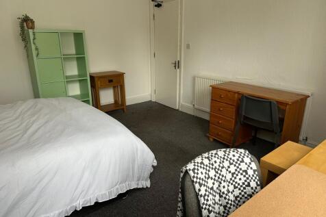 A cozy student bedroom featuring a double bed w...