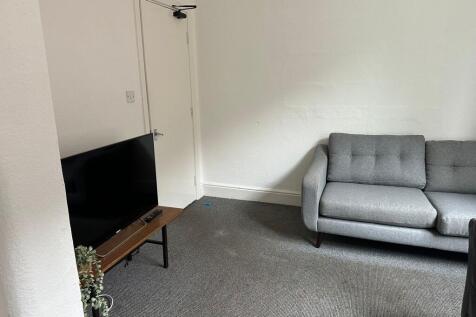 A spacious and clean living room featuring a co...