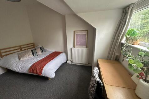 A spacious and inviting bedroom with a comforta...