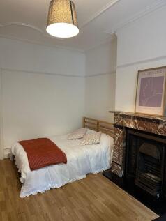 A cozy double bedroom featuring a simple bed wi...