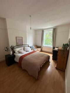 A spacious and well-lit bedroom featuring a com...