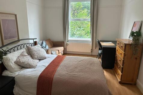 A well-lit, cozy living room with a large windo...