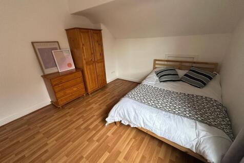 A tidy, well-lit double bedroom featuring a com...