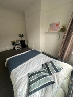A welcoming double bedroom featuring a neatly m...