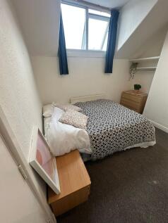 Cozy double bedroom featuring a neatly made bed...