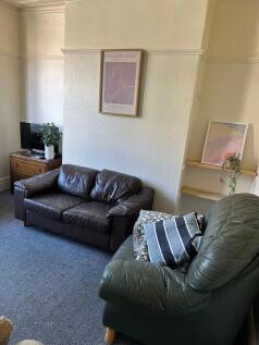 A cozy living room featuring two leather sofas,...