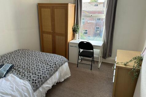 A bright and tidy single bedroom featuring a ne...