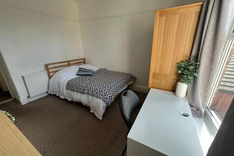 A cozy single bedroom featuring a comfortable b...