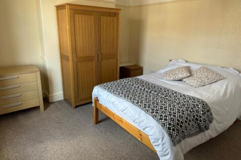 A bright and inviting double bedroom with a woo...