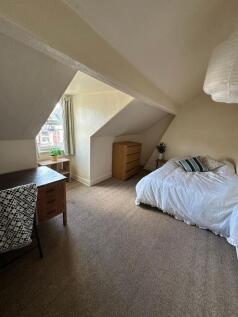 Bright and cozy master bedroom featuring a comf...