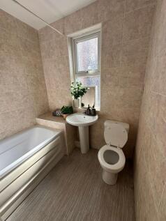 Bright and clean bathroom with a bathtub, a sma...