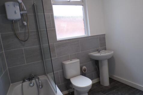 A clean, modern bathroom featuring a bathtub wi...