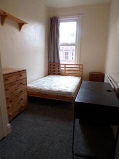 A modest and tidy bedroom featuring a single be...