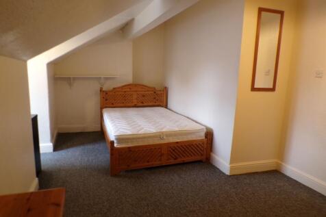 A cozy single bedroom with sloped ceiling, feat...