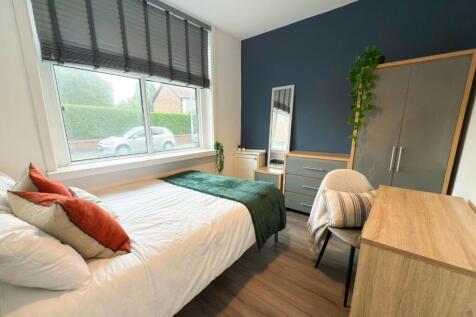 A bright and welcoming bedroom featuring a neat...