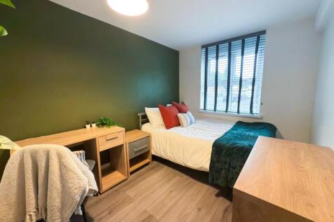 A bright and tidy bedroom featuring a double be...