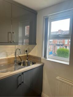 A modern kitchenette with ample natural light, ...