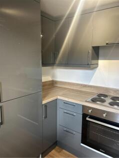 A modern and tidy kitchenette with sleek grey c...