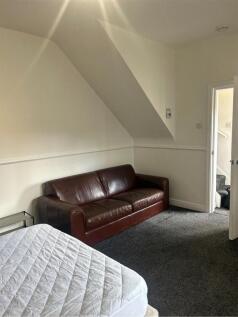 A cozy double bedroom with a comfortable seatin...