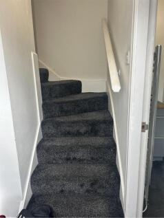 A well-maintained staircase with clean carpetin...