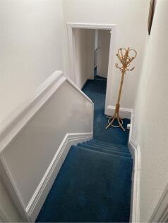 A tidy staircase with a stylish coat stand, lea...
