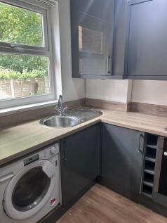 A modern kitchenette with ample storage and nat...