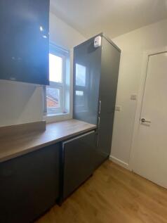A modern and tidy kitchenette with ample storag...