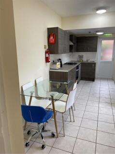 A modern kitchen featuring a glass dining table...