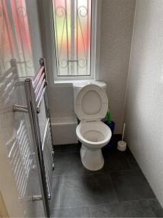 A tidy and functional single toilet with natura...