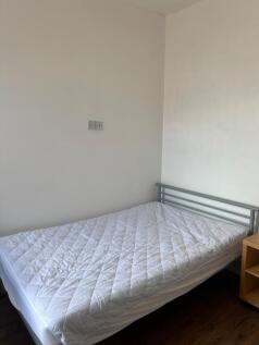 A cozy double bedroom with ample space and natu...