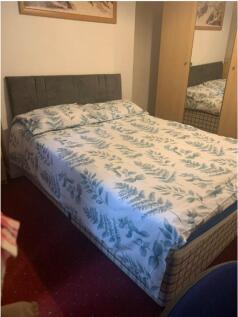 A cozy double bedroom featuring a comfortable b...