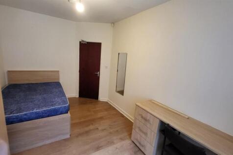 A simple, tidy bedroom featuring a double bed a...