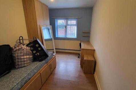 A cozy bedroom featuring a single bed with a de...