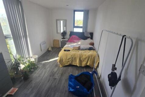 A cozy and well-lit bedroom with a bed, window ...