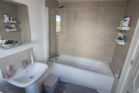 A modern, clean bathroom featuring a large bath...