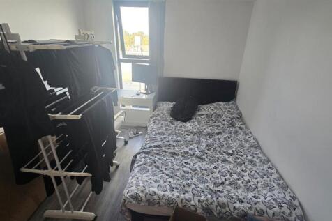 A cozy bedroom featuring a double bed with patt...