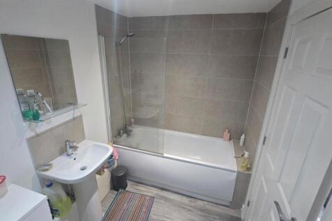 A modern, clean bathroom featuring a large bath...