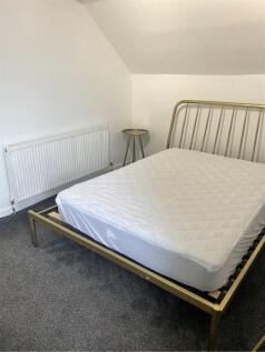 A spacious double bedroom featuring a comfortab...