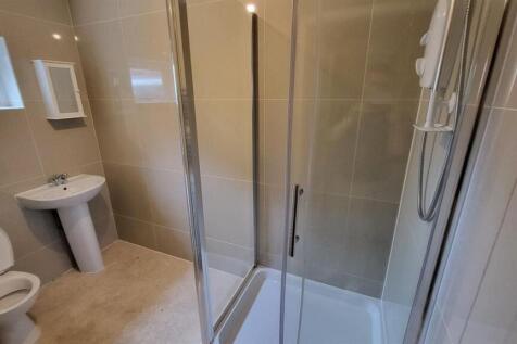 A clean and modern bathroom with a large shower...