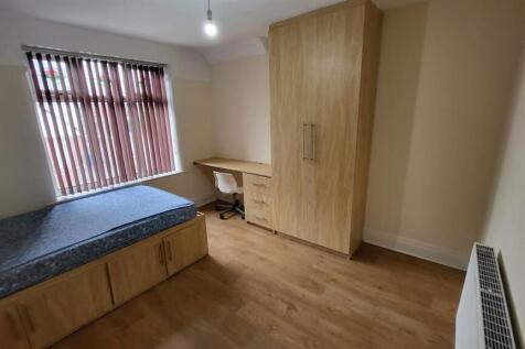 A small, clean single toilet room with basic fi...