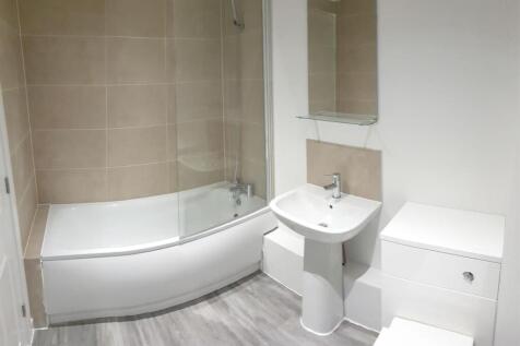 A modern, clean bathroom featuring a large bath...